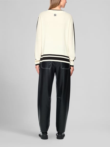 Männermodel trägt Pullover aus Wolle Alpaka mit Strukturlogo von Marc Cain, Melange-Strickoptik, Relaxed Fit, Longline, Logo-Detail, Kontraststreifen, überschnittene Schultern, sichtbare Nähte, Rundhalsausschnitt, Langarm, gerippte Abschlüsse mit Schlitzen, Ganzkörperansicht Rückansicht.