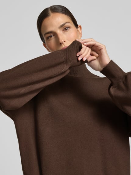 Frauenmodel trägt Strickpullover aus Viskose-Mix Modell 'Mercy East' von MSCH Copenhagen in Braun, Relaxed Fit, Nahaufnahme Oberkörper.