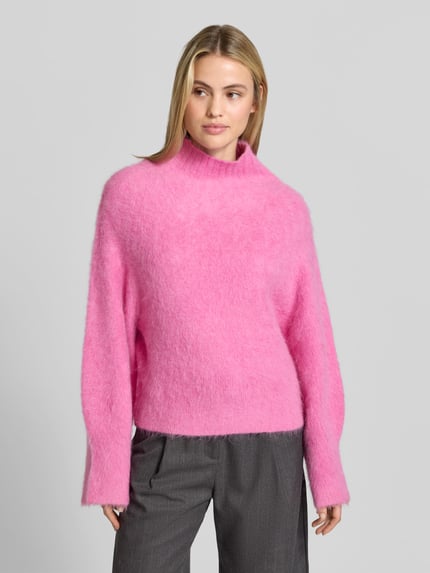 Frauenmodel trägt Sweatshirt mit Mock Neck Modell 'PROMISY' von IRO in Unifarbe Pink, Strickoptik, Strukturmuster, langarm mit geripptem Saum, Ganzkörperansicht von vorne.
