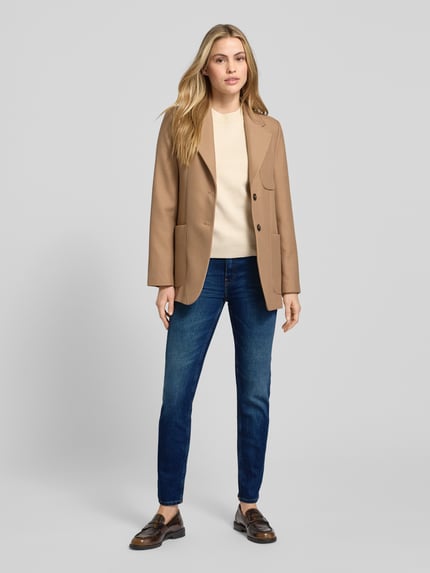 Vrouwenmodel draagt Slim Fit Jeans uit katoenmix van Tommy Hilfiger in uni blauw, regular lengte, mid waist, 5-pocket. Volledig frontaal.