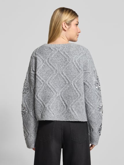 Frauenmodel trägt Strickpullover mit Pailletten und Rundhalsausschnitt von Oui in Grau mit Zopfmuster und Woll-Anteil, Ganzkörperansicht Rückansicht.