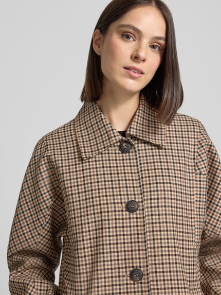 Frauenmodel trägt Mantel aus Schurwoll-Baumwoll-Mix im Allover-Look von Lanius, feines Karo-Muster in Beige und Schwarz, Nahaufnahme Oberkörper.