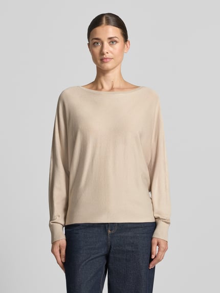 Frauenmodel trägt Strickpullover aus Viskose-Mix von COMMA in Beige, lockere Passform, Rippdetails, Ganzkörperansicht von vorne.