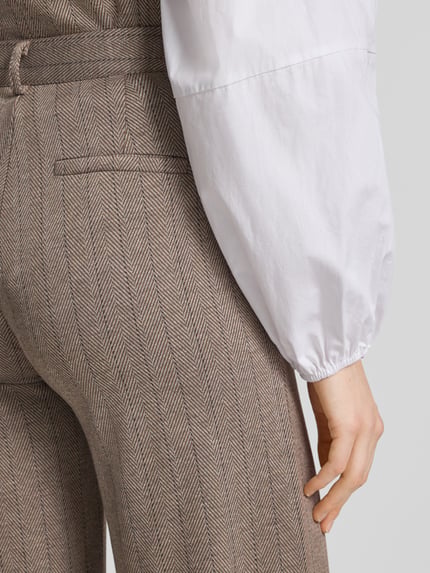 Frauenmodel trägt Straight Fit Hose mit Viskose-Anteil Modell 'Bonnie' von FREE/QUENT in braunem Fischgrätmuster, Detailaufnahme, elastischer Material-Mix.
