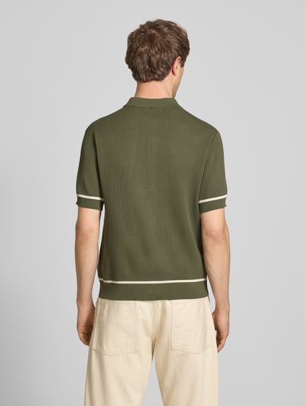 Męski model nosi Slim Fit Strick-Poloshirt mit Label-Stitching od REVIEW, z mieszanki wiskozy, krój slim fit, zielony z kontrastowymi paskami, zapięcie na guziki, długość tyłu w rozmiarze M: 65 cm, widok całej sylwetki od tyłu.
