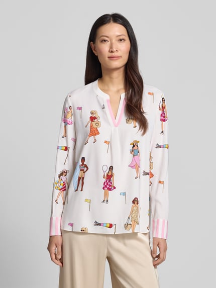 Kobiece model nosi Relaxed Fit Tunika-Bluse mit Allover-Motiv-Print od HERZENS, białe kolory z nadrukiem z motywem na całej powierzchni, z długim rękawem i dekoltem z lamówką, długość tyłu dla rozmiaru 36: 70 cm, długość rękawów: 63 cm, widok na całą sylwetkę z przodu.