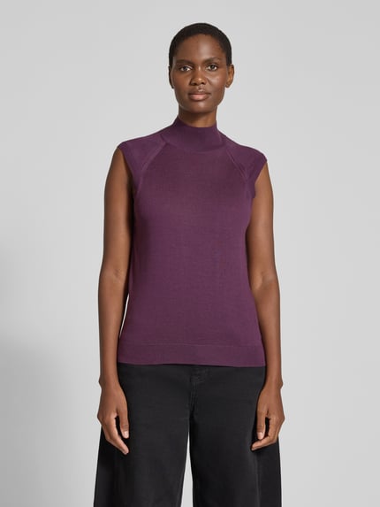 Frauenmodel trägt Pullunder aus Wolle mit Mock Neck von BOSS, unifarben in matt violett, Feinstrick mit Strukturmuster, Ganzkörperansicht von vorne.