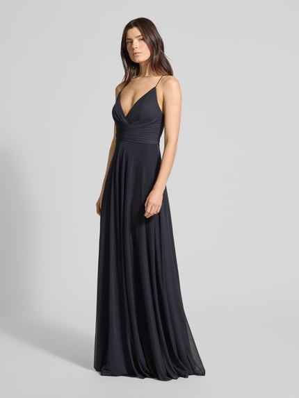 Modelka nosi Długa sukienka 'Maxikleid in Wickel-Optik mit rückseitiger Schnürung' od Jake*s Cocktail, mieszanka materiałów z dodatkiem streczu, linia A, kopertowy styl, wiązanie z tyłu, długość tyłu w rozmiarze 36: 135 cm, szerokość w rozmiarze 36: 34 cm, kolor ciemnogranatowy, gładka tekstura, widok całej sylwetki z przodu.