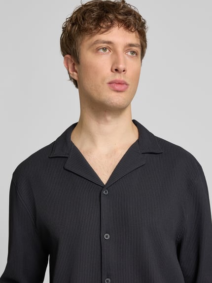 Männermodel trägt Regular Fit Langarmhemd in Plissee-Optik von REVIEW, Schwarz, Material-Mix mit Stretch-Anteil, Nahaufnahme Oberkörper.