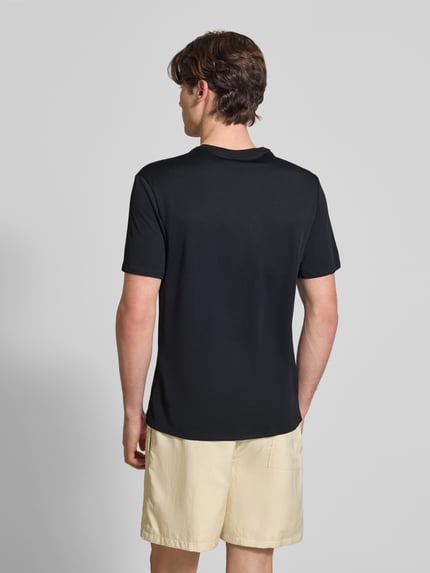 Männermodel trägt T-Shirt mit Rundhalsausschnitt und Logo von NIKE TRAINING, schwarz, Regular Fit, Kontraststreifen, Rückansicht, Ganzkörperansicht Rückansicht.