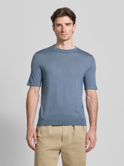 Mannelijk model draagt t-shirt uit wol model 'Connor' van Tiger Of Sweden, recht model, ronde hals, 1/2-mouwen, ruglengte maat M 70 cm, mouwlengte maat M 34 cm, blauwe kleur, gladde textuur, effen design, zicht van voren, nahaufnahme bovenlichaam.