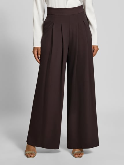 Vrouwenmodel draagt Wide Leg Stoffhose met Reißverschlusstaschen van Rinascimento, bruine Materiaalmix met stretch, elastische band, zij-ritszakken, bandwijdte maat S 37 cm, binnenbeenlengte maat S 82 cm, detailopname onderlichaam.