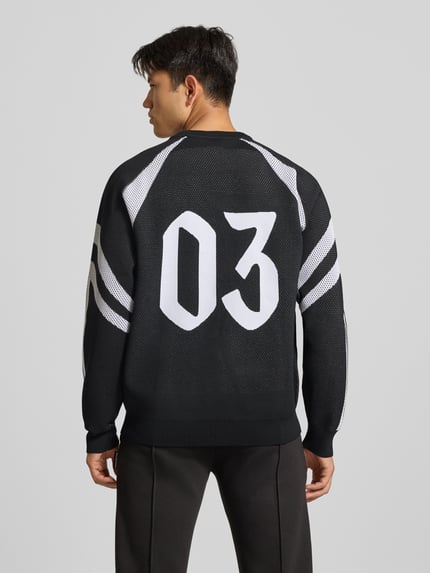 Mannelijk model draagt Pullover met groot logo-schriftzug van adidas Sportswear, meerkleurig gestreept, gemêleerde textuur, geheelopname achteraan.