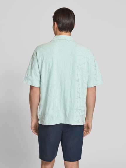 Männermodel trägt Regular Fit Freizeithemd aus Baumwoll-Mix Modell 'WE_FLOWER' von BOSS Orange, Optik: Unifarben, Strukturiert, Strukturmuster, Label-Stitching, Ärmelform: Kurzarm, Materialverarbeitung: Frottee, Ganzkörperansicht Rückansicht.
