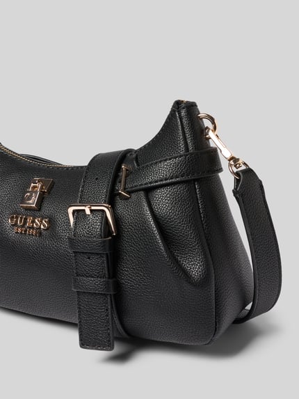 Produktfoto, schwarze Handtasche mit Label-Applikation Modell 'YESBA' von Guess, strukturierte Oberfläche, goldfarbene Details, Hauptfach mit Reißverschluss, abnehmbarer Schulterriemen, Maße 26x14x10 cm, Länge Schulterriemen 67 cm.
