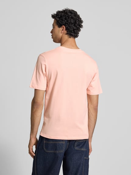 Męski model nosi T-shirt z nadrukiem z napisem model 'RHYERES' od Jack & Jones, woskowana bawełna, krój regular fit, okrągły dekolt, długość tyłu w rozmiarze M: 67 cm, widok całej sylwetki z tyłu.