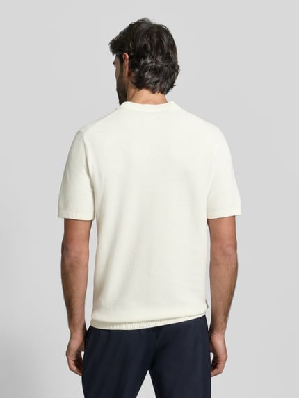 Męski model trägt Regular Fit T-Shirt aus reiner Baumwolle von MCNEAL w kolorze kremowym z prążkowaną stójką i fakturowanym wzorem, prążkowane wykończenia, długość tyłu w rozmiarze M: 71 cm, długość rękawa: 27 cm, krój regular fit, widok całej sylwetki z tyłu.