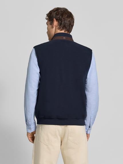 Männermodel trägt Steppweste mit Stehkragen und Eingrifftaschen von bugatti in Dunkelblau, Baumwoll-Mix, gerader Schnitt, Ganzkörperansicht Rückansicht.