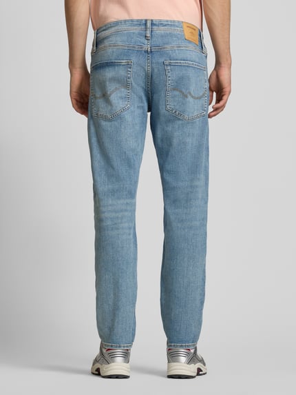 Männermodel trägt Slim Fit Jeans im 5-Pocket Design Modell 'Mike' von Jack & Jones, hellblauer Denim, Baumwoll-Mix, Ganzkörperansicht Rückansicht.