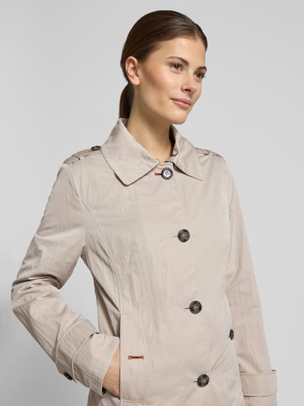 Frauenmodel trägt Slim Fit Jacke mit Umlegekragen und Taschen mit Knopfverschluss von Gil Bret in Beige, matte Oberfläche, Nahaufnahme Oberkörper. Rückenlänge 63 cm, Schulterbreite 39 cm, Brustweite 50 cm, Ärmellänge 65 cm.