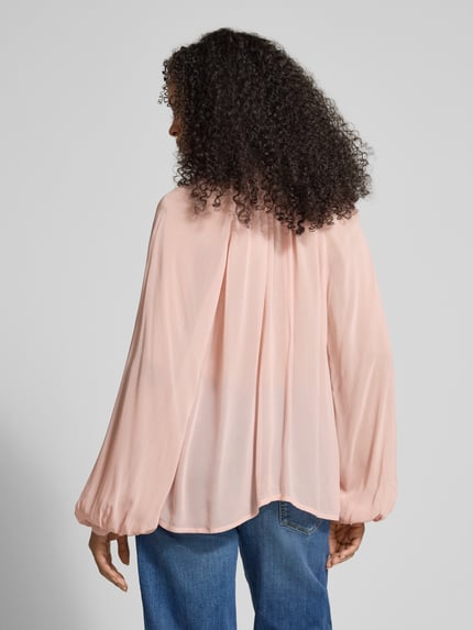 Vrouwenmodel draagt Relaxed Fit Bluse mit Schnürung und Volants van Jake*s Collection in lichtroze, vloeiende stof, rugaanzicht, relaxed fit, keyhole-halslijn, ruches, ruglengte 64 cm, mouwlengte 65 cm. Ganzkörperansicht Rückansicht.