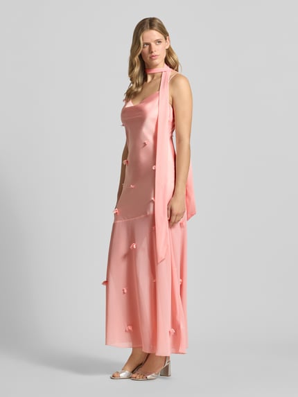 Vrouwenmodel draagt Maxikleid met floralem besatz van Gina Tricot in satijn, nauwsluitend, cascadehals, spaghettibandjes, bloemenmotief, ruglengte maat 36: 133 cm, borstwijdte maat 36: 34 cm, hele lichaam aan de voorzijde.