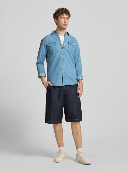 Männermodel trägt Slim Fit Freizeithemd mit Kentkragen Modell 'ESHERIDAN' von JACK & JONES aus Baumwolle, Ganzkörperansicht von vorne