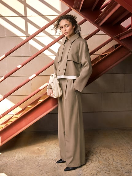 Frauenmodel trägt Trenchjacke mit Druckknopfverschluss von Jake*s Collection in Beige, Regular-Fit, Umlegekragen, Zweireiher, Ganzkörperansicht von vorne