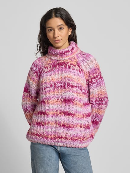 Vrouwenmodel draagt Strickpullover met Rollkragen van Smith and Soul, grofgebreid, relaxed fit, gemengde tinten roze en paars, materiaal-mix met alpaca, voorkant geheel zichtbaar, bovenlichaam close-up.