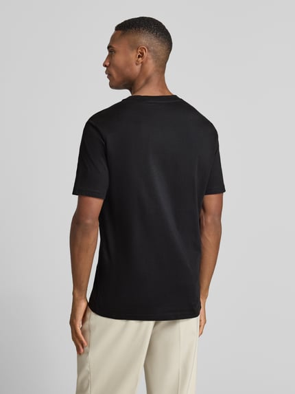 Männermodel trägt T-Shirt mit Label-Print von MARC O'POLO in Schwarz, gerader Schnitt, reine Baumwolle, Rückansicht, Ganzkörperansicht