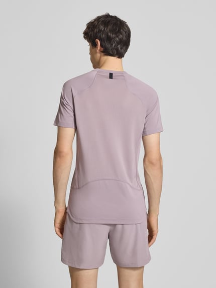 Männermodel trägt T-Shirt mit Logo-Print und Raglanärmeln von NIKE TRAINING in Flieder, Straight Fit, Rückenlänge 71 cm, Ganzkörperansicht Rückansicht.