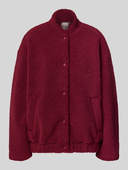 Produktfoto, Teddyjacke mit Eingrifftaschen Modell 'Pile' von aim'n in dunklem Rot, weiche Teddyfell-Textur, gerader Schnitt, Stehkragen, sichtbare Druckknöpfe, seitliche Taschen, strukturierte Oberfläche.