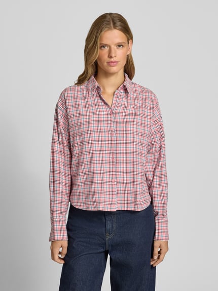 Vrouwenmodel draagt Relaxed Fit Hemdbluse aus reiner Baumwolle Modell 'Jamie' van JJXX met rood-wit-blauw ruitpatroon, knoopsluiting, lange mouwen, hemdkraag, context: pure katoen, relaxed fit, lengte rug en mouw bij maat S 59 cm, geheel gezichtsaanzicht.