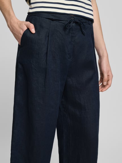 Frauenmodel trägt Leinenhose mit Bindegürtel von Christian Berg Woman in Dunkelblau, Reines Leinen, Knopfverschluss, Nahaufnahme Oberkörper.