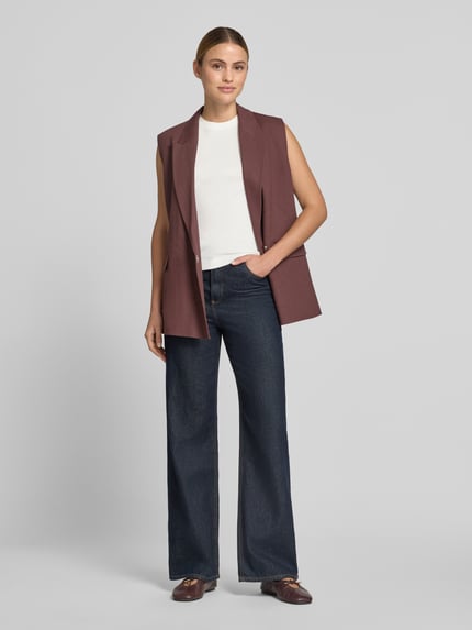 Frauenmodel trägt Tanktop aus Baumwolle mit Rundhalsausschnitt von JAKE*S STUDIO WOMAN in Weiß, Regular-Fit, Reine Baumwolle, Rückenlänge bei Größe 38: 57 cm, kombiniert mit dunkler Jeans und brauner ärmelloser Weste, Ganzkörperansicht von vorne.