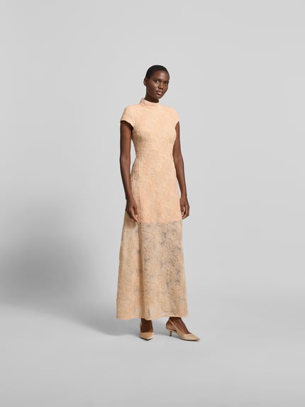 Modelka kobieca nosi Maxikleid mit floralen Allover-Details od ROTATE, elastyczny materiał, krój taliowany, beżowe kwiatowe wzory, długość całkowita 142 cm w rozmiarze 36, szerokość w rozmiarze 36: 38 cm, stójka, krótkie rękawy, widok całej sylwetki z przodu
