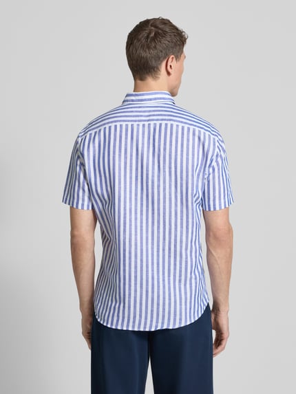 Męski model nosi Slim Fit Business Hemd aus Leinen-Misch mit Kentkragen von Jake*s, mieszanka lnu i bawełny, krój slim fit, kołnierzyk typu kent, listwa guzikowa, krótki rękaw, długość tyłu w rozmiarze M: 75 cm, szerokość ramion w rozmiarze M: 43 cm, długość rękawów w rozmiarze M: 25 cm, biało-niebieskie pionowe paski, widok całego ciała z tyłu.