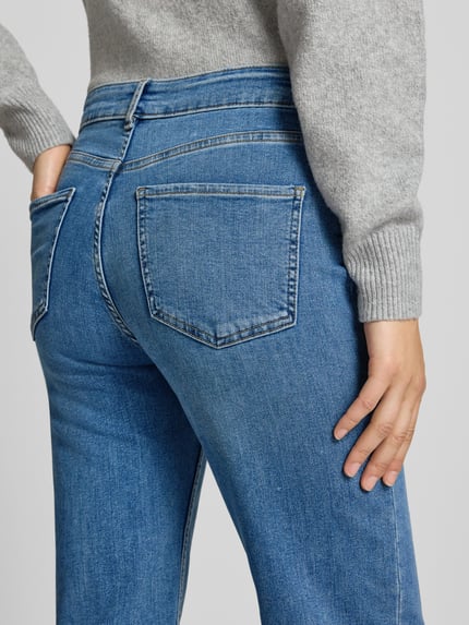 Frauenmodel trägt Straight Fit Jeans im 5-Pocket-Design von REVIEW aus elastischem Bio-Baumwoll-Mix in Mittelblau, Detailaufnahme Rückansicht.