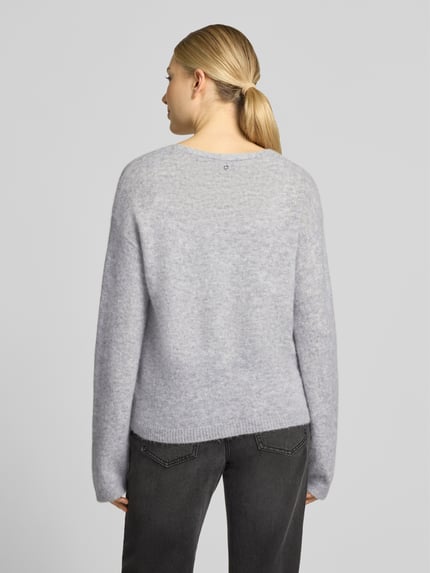 Vrouwenmodel draagt gebreid jack van alpaka-mix met wol, melangelook, relaxed fit, labeldetail, v-hals, door BOSS Orange, model 'C_Farano', rompzoom en mouwboord geribd, gemêleerde textuur, helemaal zichtbaar van achteren.
