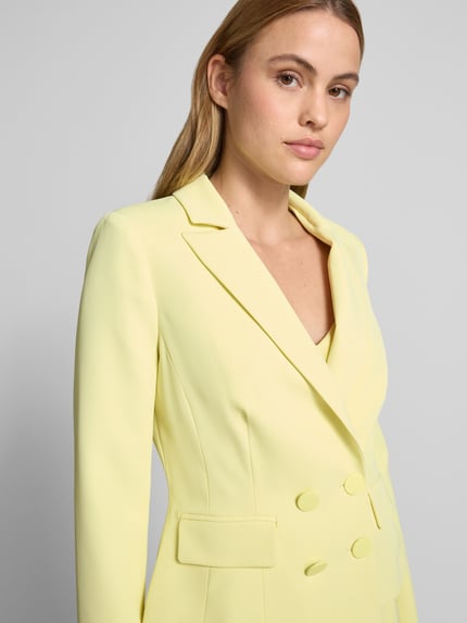 Frauenmodel trägt Blazer mit Reverskragen und doppelreihigem Knopfverschluss von Rinascimento in Gelb, taillierter Schnitt, Nahaufnahme Oberkörper.