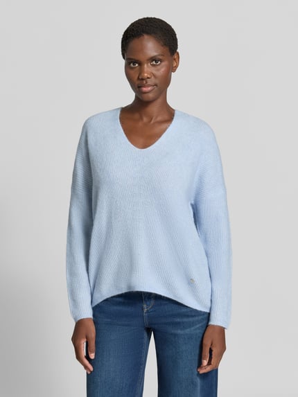 Kobiece model prezentuje sweter z dzianiny z mieszanki wełny z domieszką alpaki, krój regular fit, dekolt w serek, MOS MOSH Strickpullover aus Woll-Mix mit V-Ausschnitt Modell 'THORA', jasnoniebieski, długość tyłu w rozmiarze S: 82 cm, długość rękawów: 46 cm, widok całej sylwetki od przodu.