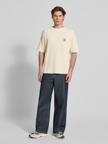 Männermodel trägt Herren T-Shirt mit Strukturmuster Modell 'Nelson' von Carhartt Work In Progress, Reine Baumwolle, Relaxed-Fit, Label-Detail, Rundhalsausschnitt, Rückenlänge bei Größe M 70 cm, Ganzkörperansicht von vorne.