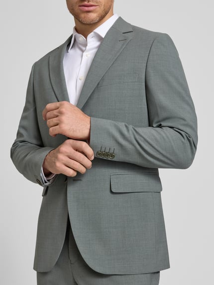 Männermodel trägt Regular Fit Blazer mit Lanawoll-Anteil Modell 'Charles' von Matinique, elastyczna mieszanka materiałów, kołnierz z połami, brustasza, kieszenie z wypustkami, listwa z 2 guzikami, długość tyłu w rozmiarze 50: 75 cm, szerokość w rozmiarze 50: 46 cm, długość rękawów w rozmiarze 50: 66 cm, jasnoszary odcień, gładka struktura, nahaufnahme górnej części ciała.