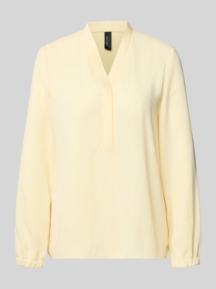 Produktfoto, Regular Fit Bluse mit V-Ausschnitt von Marc Cain in zartem Gelb, Label-Detail, lange Ärmel, glatte Textur, Rückenlänge 64 cm, Ärmellänge 61 cm bei Größe 36
