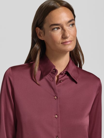Frauenmodel trägt Slim Fit Bluse aus Satin Modell 'IDEALE' von MANGO in Burgunderrot, glatte Oberfläche, Nahaufnahme Oberkörper.
