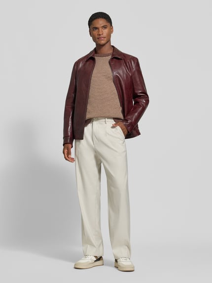Männermodel trägt Relaxed Fit Strickpullover mit Streifen-Muster Modell 'NEELIO' von DRYKORN, Material-Mix mit Woll-Anteil, cremefarbene Hose, Ganzkörperansicht von vorne.