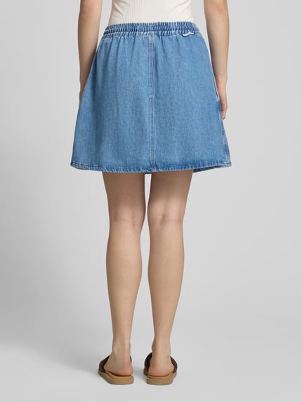 Frauenmodel trägt Ausgestellter Jeansrock aus reiner Baumwolle von Marc O'Polo Denim, blauer Denim, Mini-Länge, elastischer Bund, Ganzkörperansicht Rückansicht.