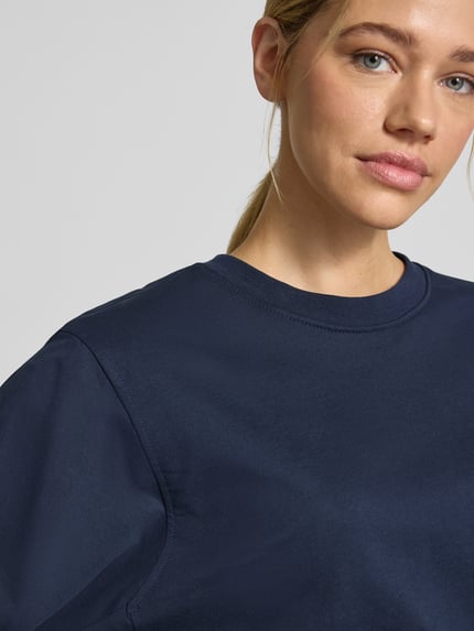 Kobieta nosi granatową bluzę Sweatshirt mit Rundhalsausschnitt Modell 'Saida' od FREE/QUENT z czystej bawełny organicznej, krój relaxed fit, zbliżenie na górną część ciała