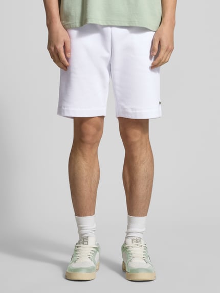 Männermodel trägt Regular Fit Sweatshorts aus Baumwoll-Mix von Lacoste in Optik: Unifarben mit Label-Patch, Ganzkörperansicht von vorne.