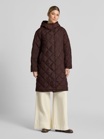 Frauenmodel trägt Steppmantel mit Kapuze Modell 'Olga' von FREE/QUENT in Dunkelbraun, Rautensteppung, Ganzkörperansicht von vorne. Damen Steppmantel, Regular Fit, Knopfleiste, Rückenlänge 98 cm, Schulterbreite 47 cm, Brustweite 55 cm, Ärmellänge 60 cm.